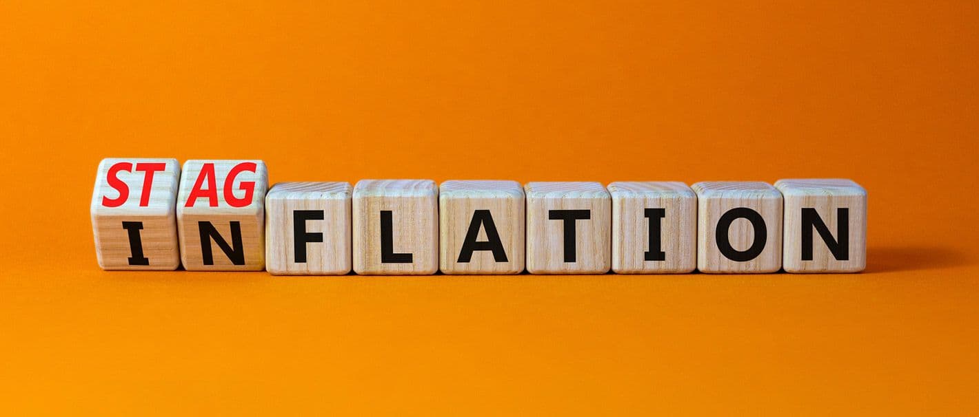 Buchstabenwürfel, die das Wort Inflation bilden und sich gerade zum Wort Stagflation weiterdrehen