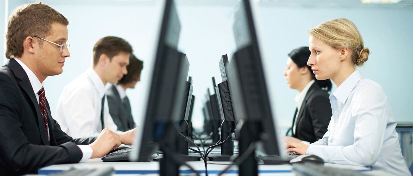 On the left side, two men are sitting in front of their desktop. L and two women are stt