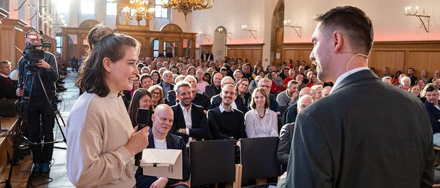 Nina Heinicke, Studentin der Sozialökonomik an der Friedrich-Alexander-Universität Erlangen-Nürnberg im Gespräch mit dem Moderator bei den Nürnberger Gesprächen 2026.