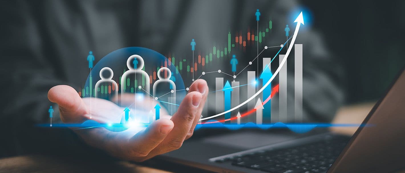 In einer virtuellen Darstellung schweben drei Personen-Icons sowie verschiedene Diagrammdarstellungen mit Aufwärts-Trend über der Hand eines Geschäftsmanns