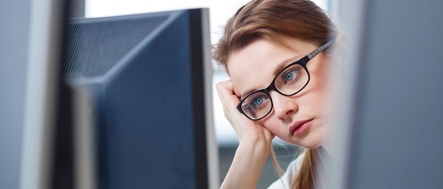Frau sitzt resigniert vor einem Computer