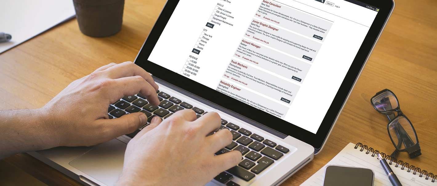 Junger Mann sucht auf dem Laptop nach Jobangeboten