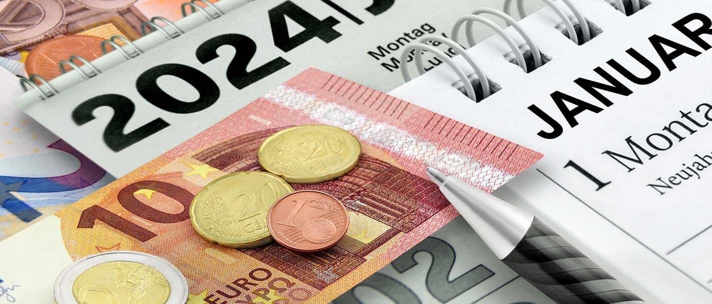 Das Bild zeigt einen Kaldender aus dem Jahr 2024 und einen 10-Euroschein sowie Centmünzen welche auf dem Kalender liegen.