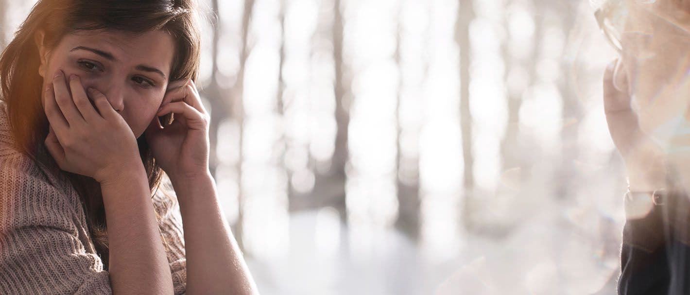 Junge Frau bei der Therapiesitzung mit einem Psychotherapeuten.