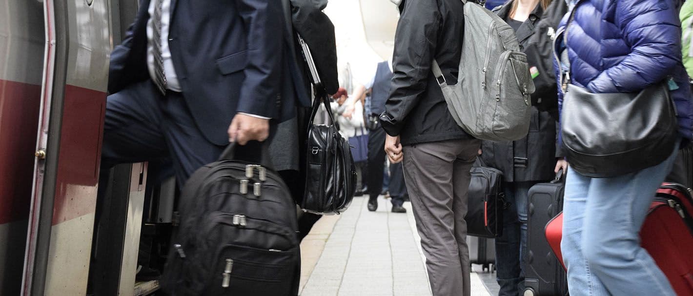 Menschen am Bahnhof steigen in einen Zug ein