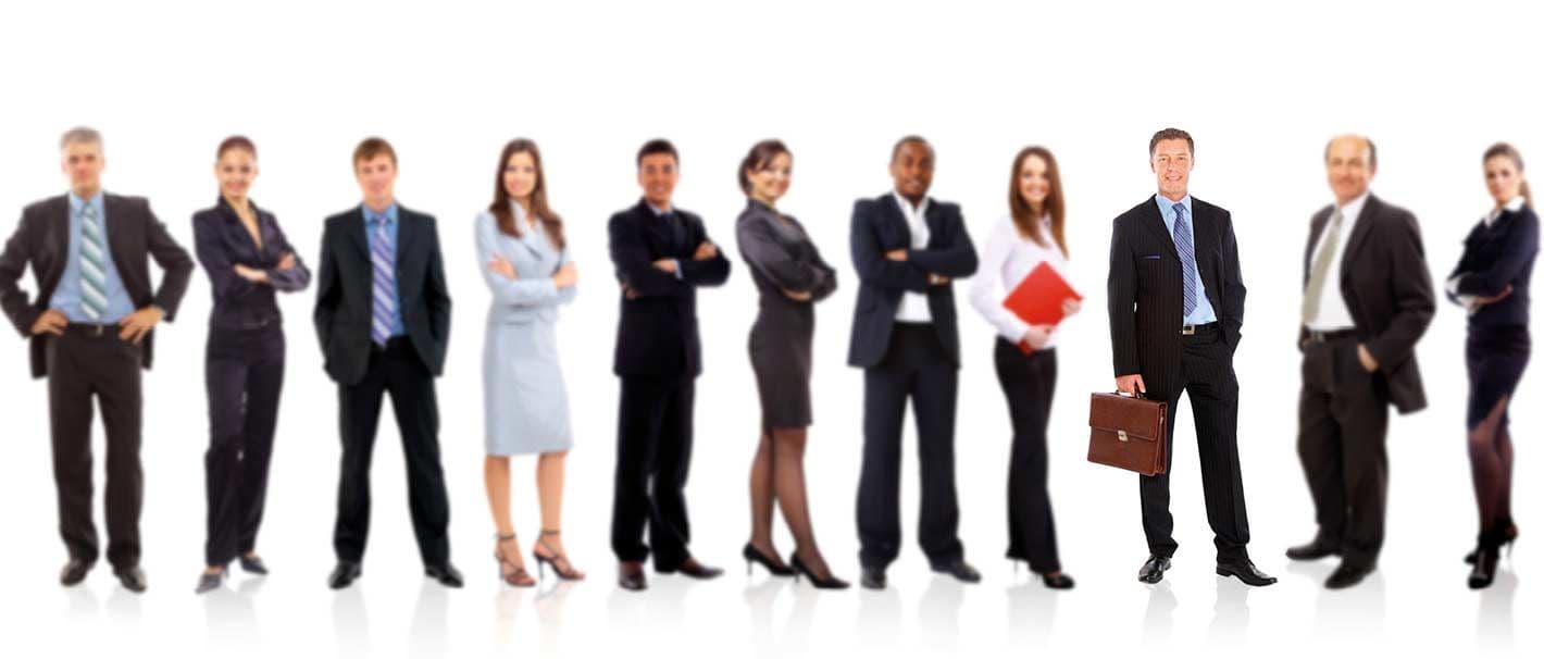 Mehrere Männer und Frauen in Business-Kleidung stehe in einer Reihe. Alle bis auf einen sind verschwommen dargestellt. Das Bild symbolisiert, dass das Individuum im Mittelpunkt steht.