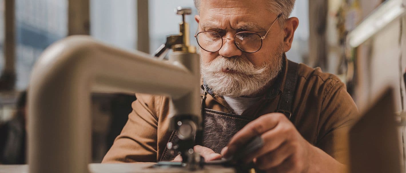 Älterer Mann arbeitet an einer Maschine