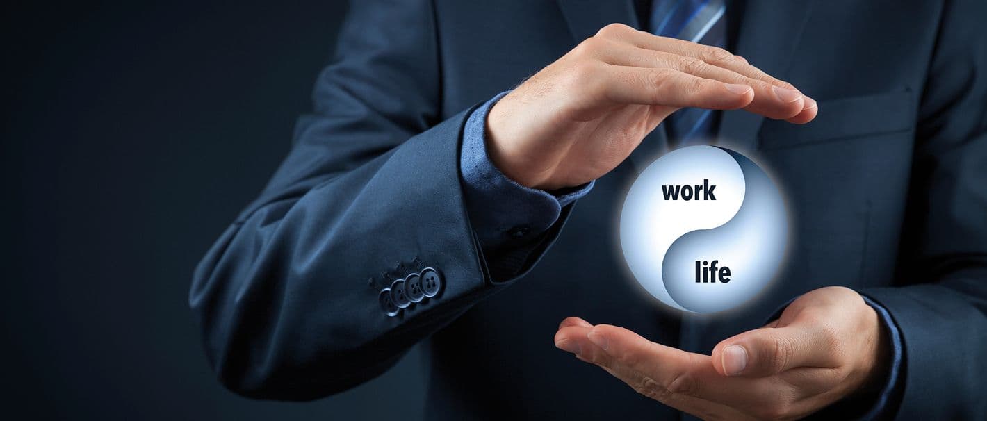 Mann im Anzug hält seine Hände schützend um einen virtuellen Kreis mit der Aufschrift „work“ und „life“